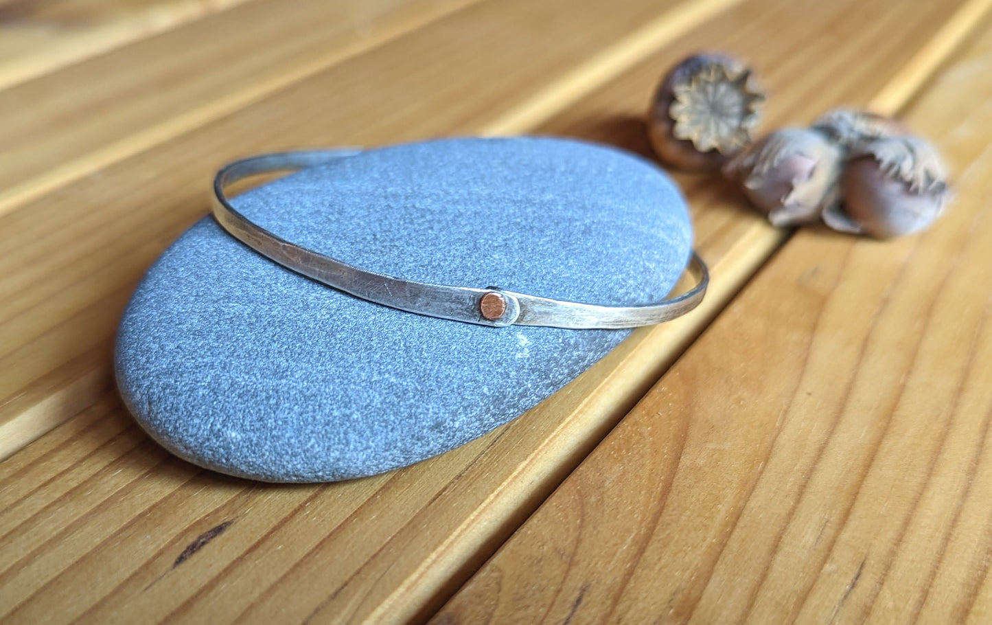 Hammered silver bangle with copper rivet