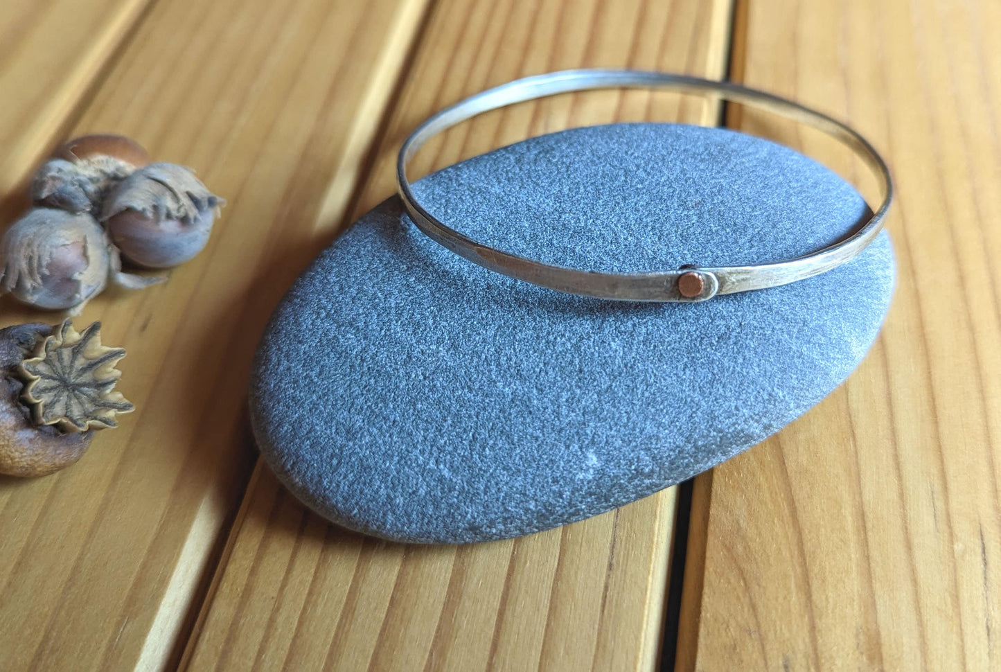 Hammered silver bangle with copper rivet